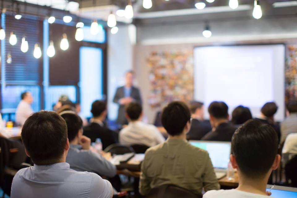 Hombre de traje hablando en una clase universitaria