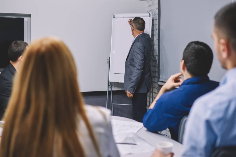 Hombre de traje dando una charla a un grupo de personas